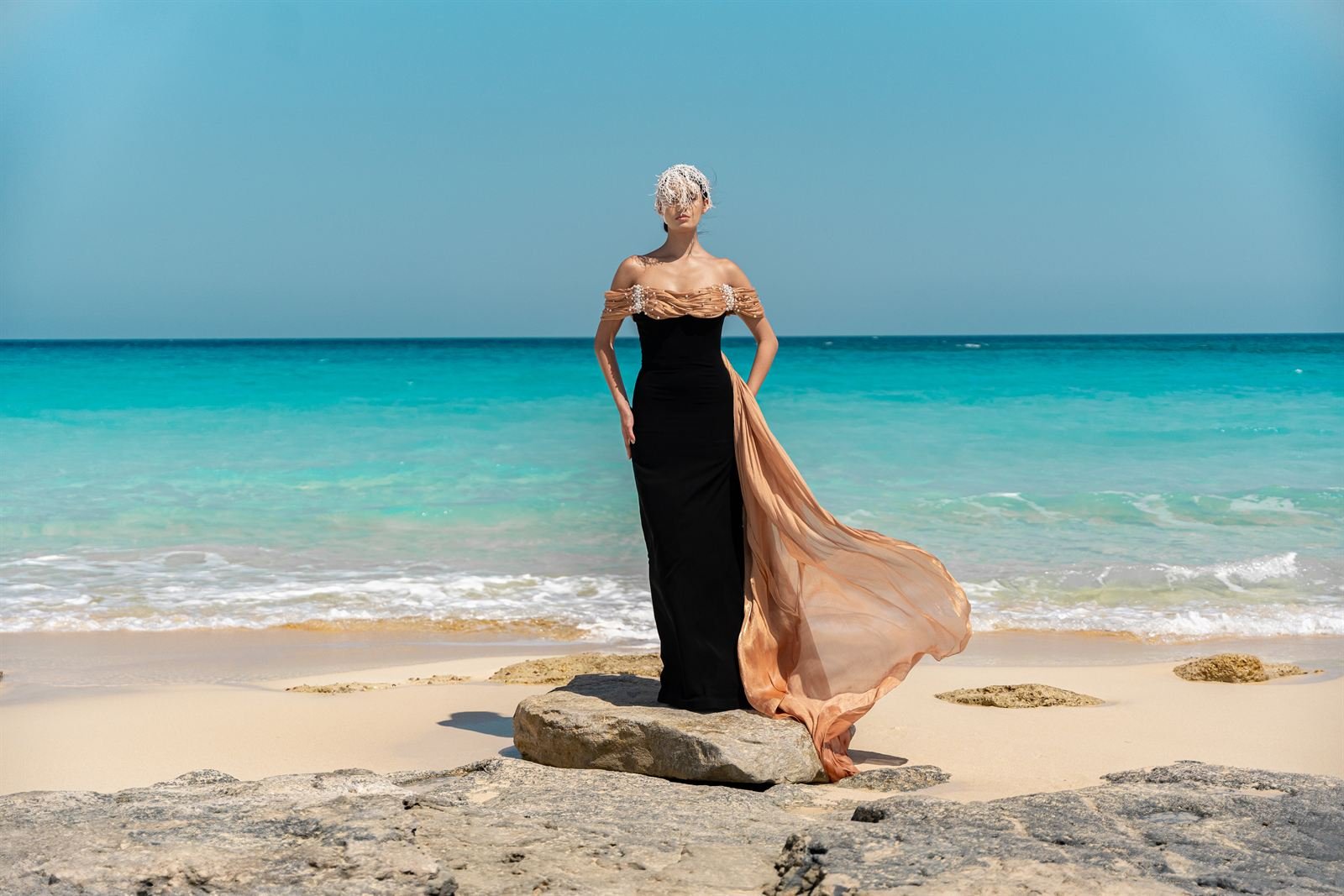 Black gown with peach train on the shoreline