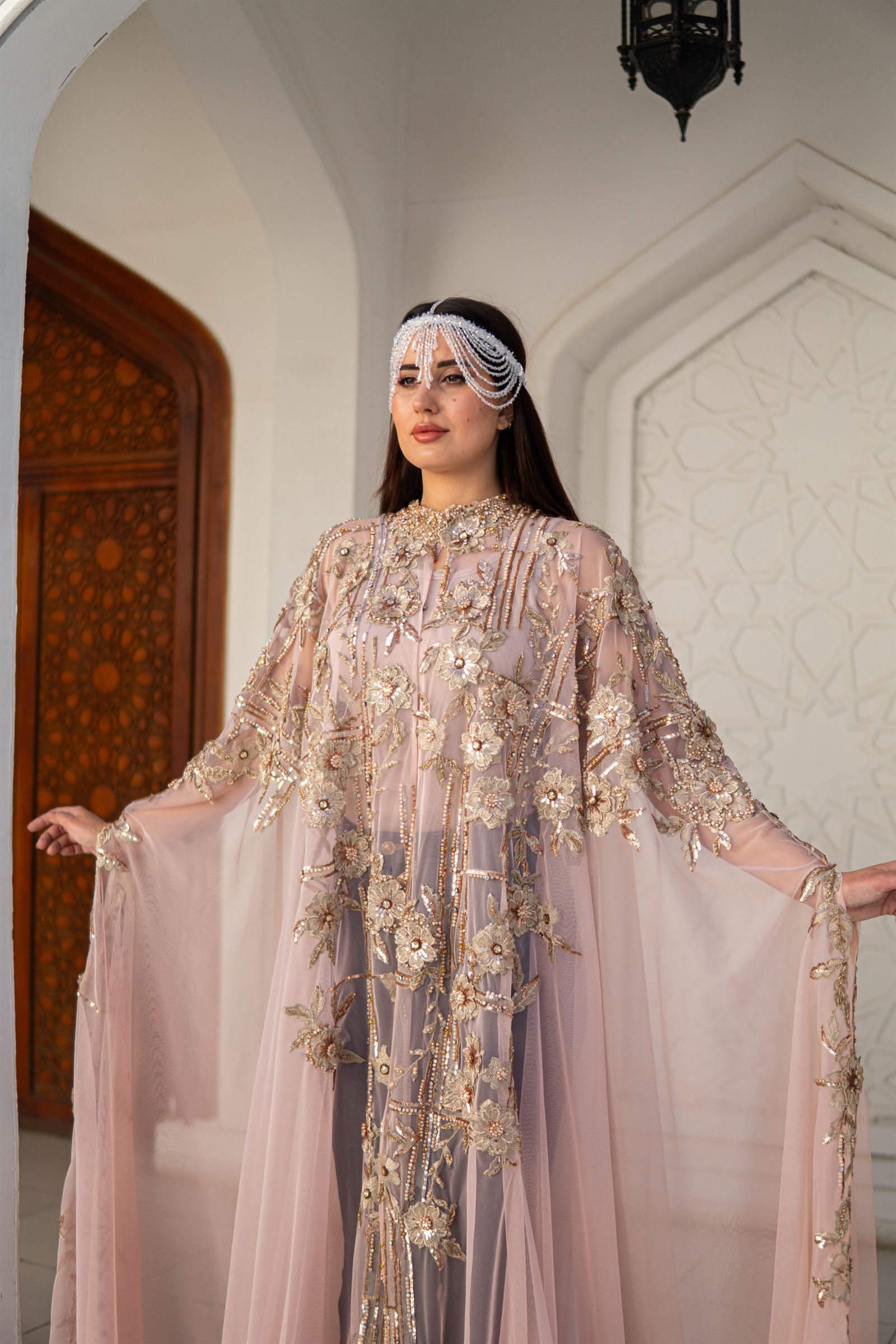 Embroidered kaftan framed by an arched doorway