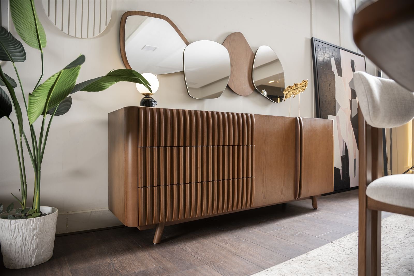 Wooden sideboard under mirrors with a plant