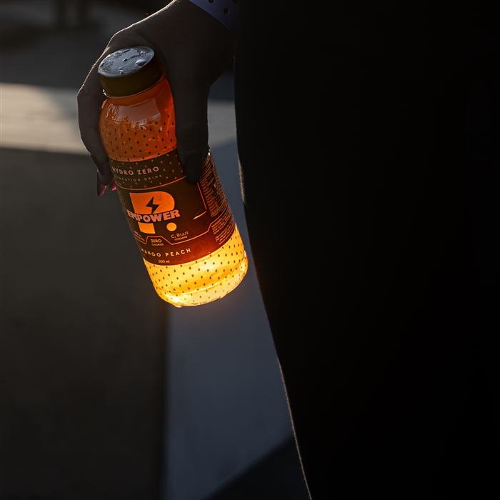 Empower — Hydro Zero, Mango Peach bottle glowing at golden hour